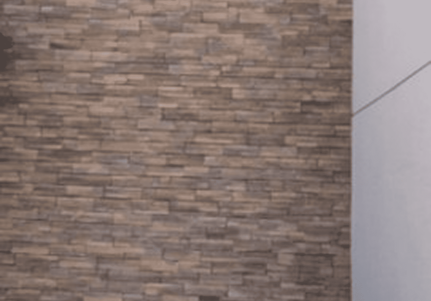 A modern wall with a textured stone brick pattern in neutral tones.