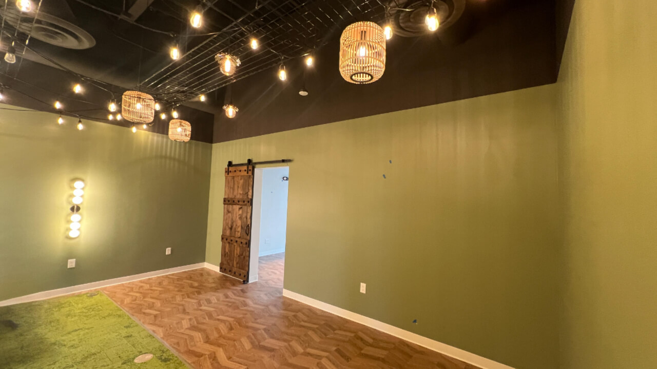 Green room with hanging lights and door.