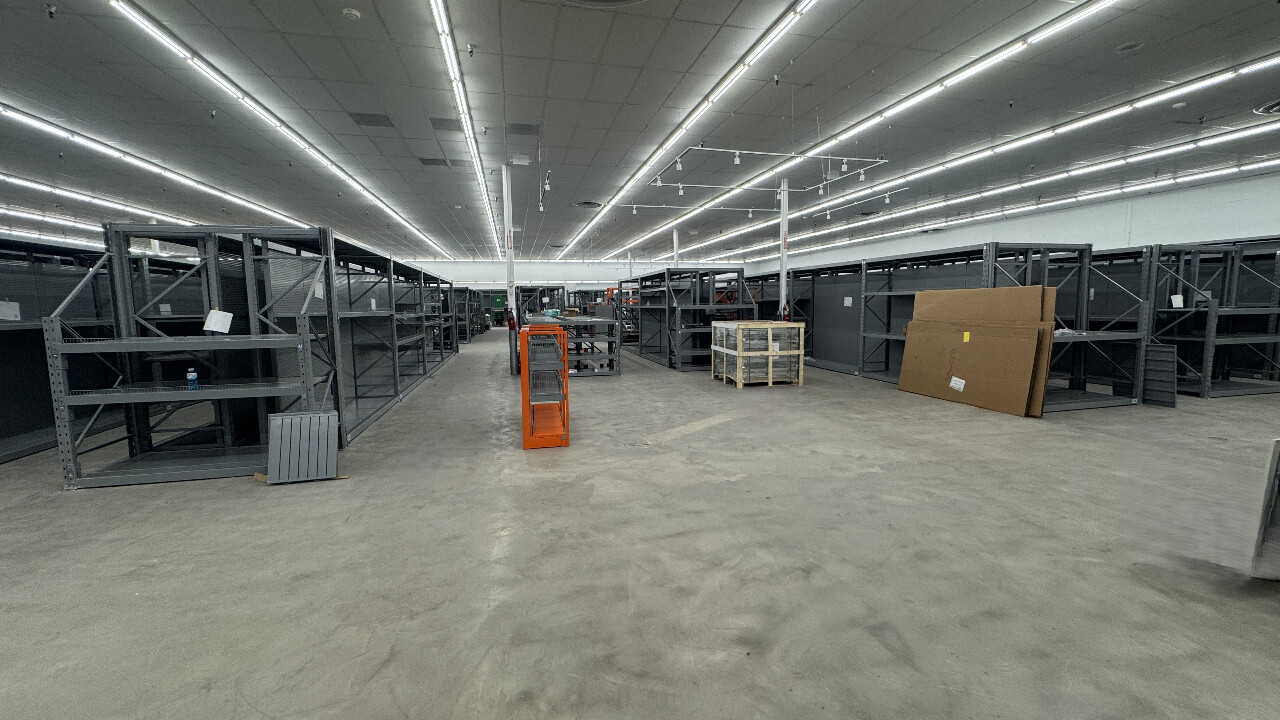 Empty warehouse with metal shelving units.
