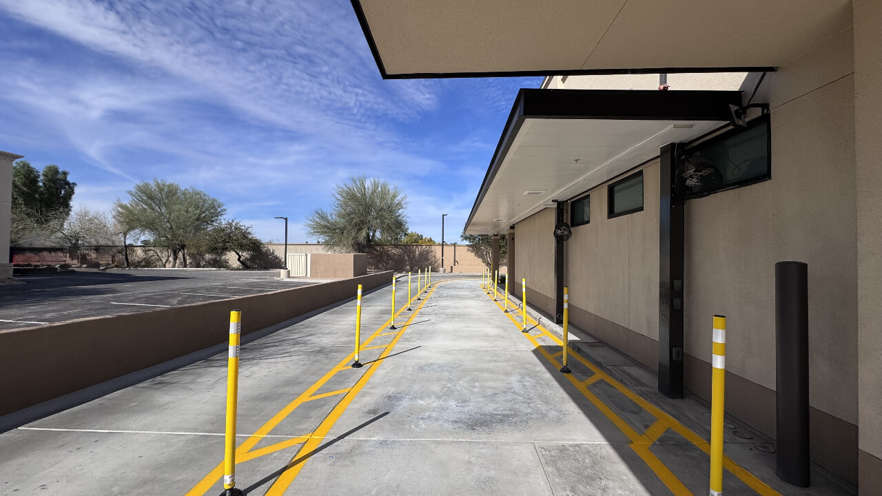 Drive-thru lane with yellow poles and markings.
