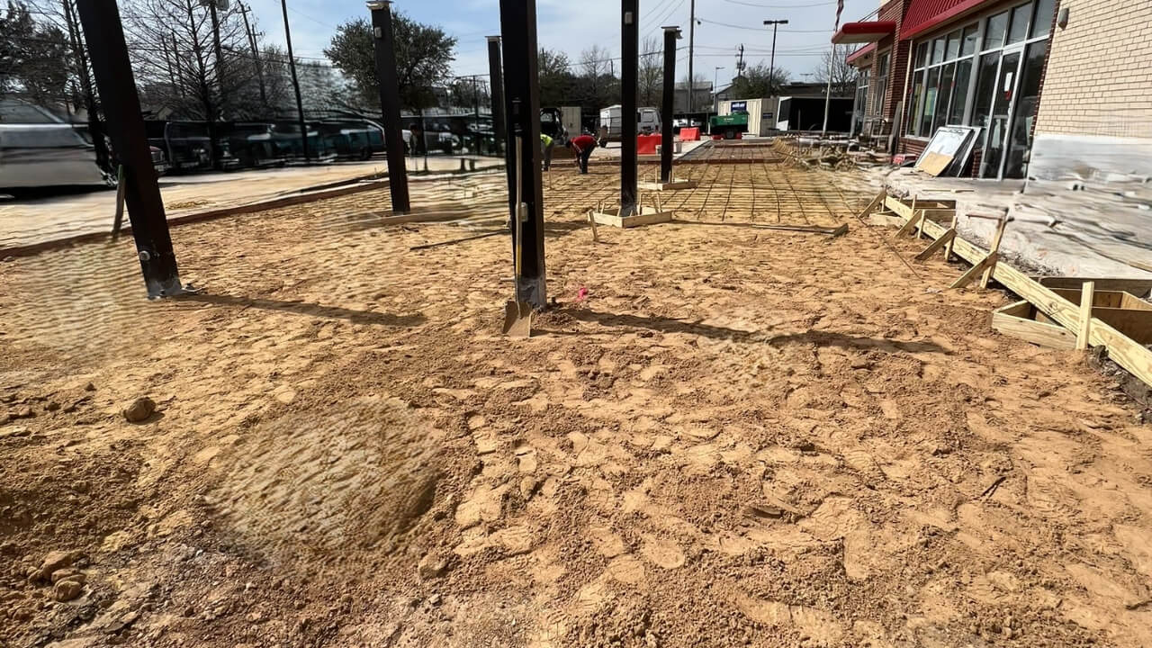 Construction site with building framework and dirt.