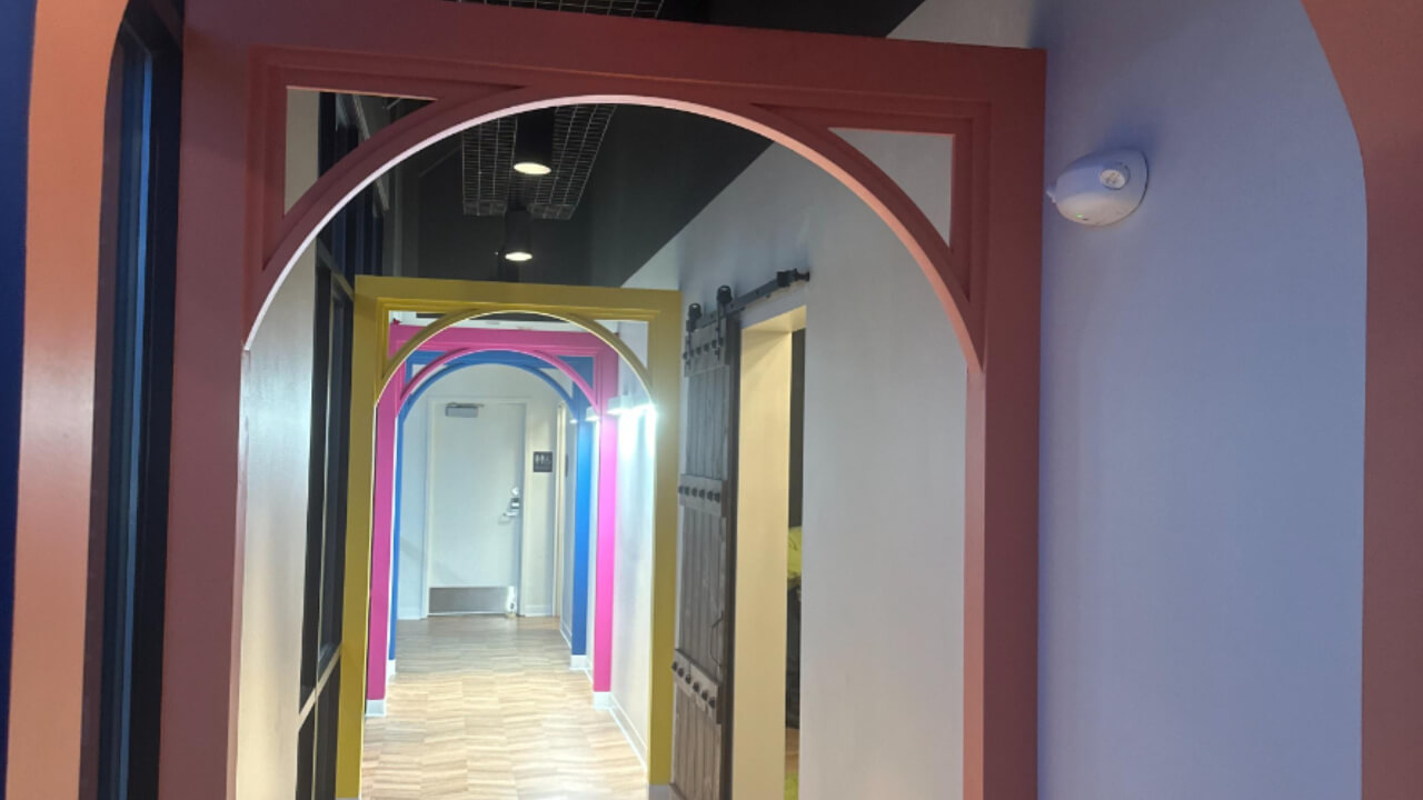 Colorful hallway with multiple archways and lights.
