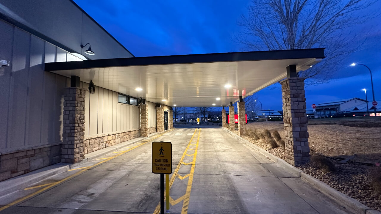 Covered drive-thru area with warning sign.