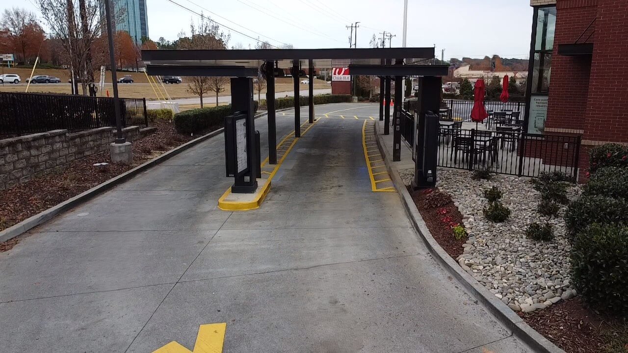 Empty drive-thru lane beside outdoor seating area.