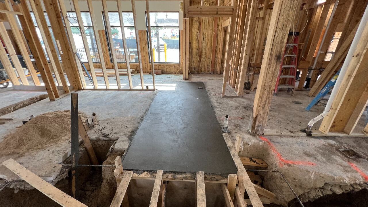 Construction site with fresh concrete floor section.