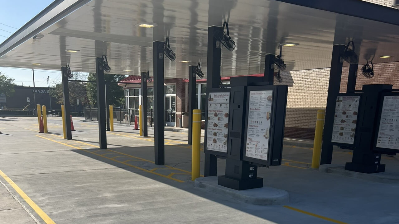 Drive-thru restaurant ordering stations under awning.