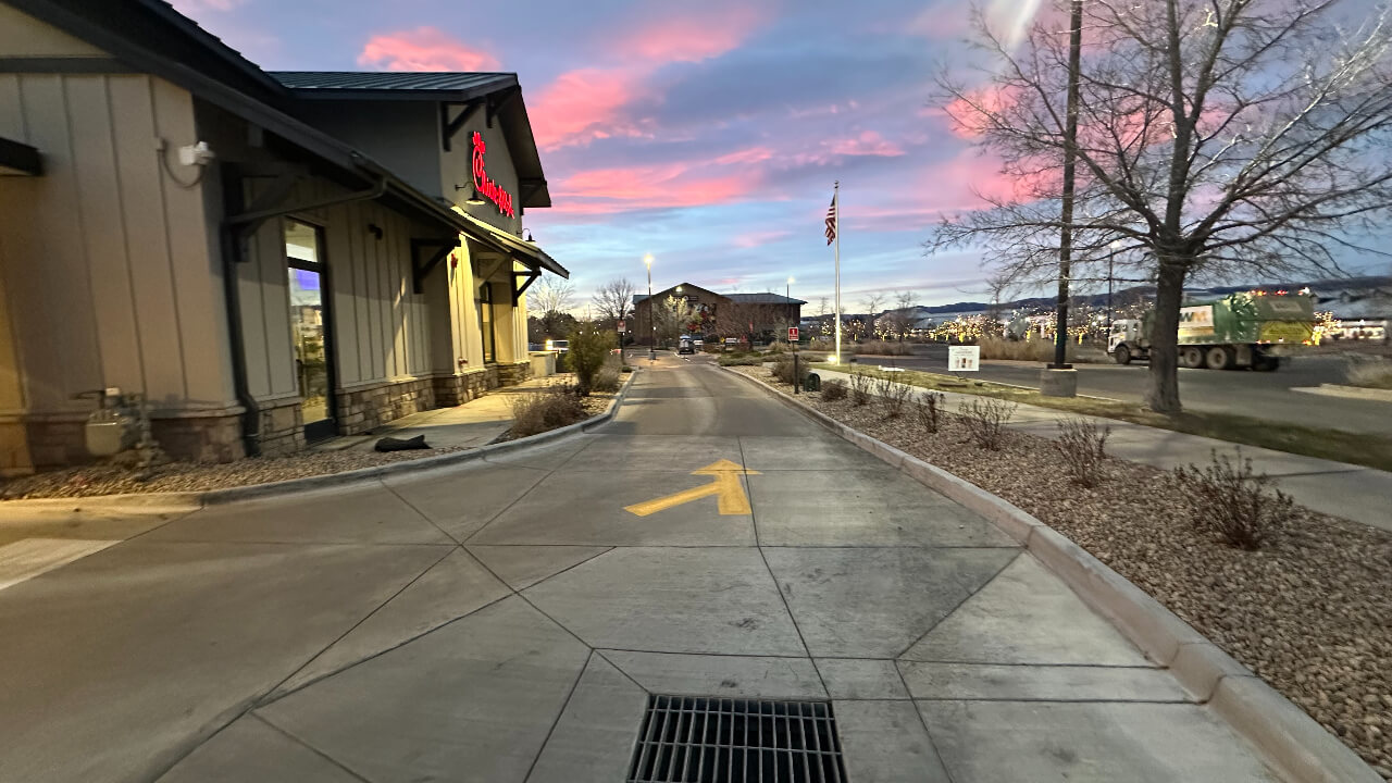 Driveway with sunset sky and building.
