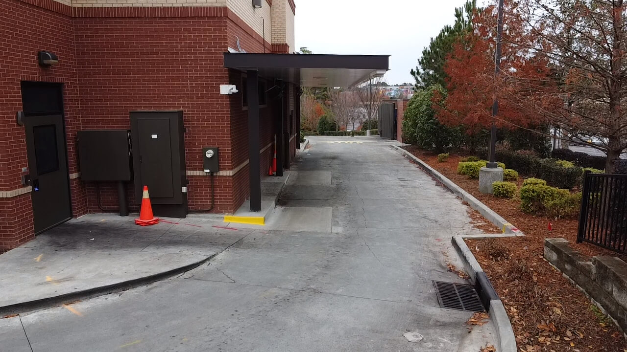Brick building with a narrow driveway.