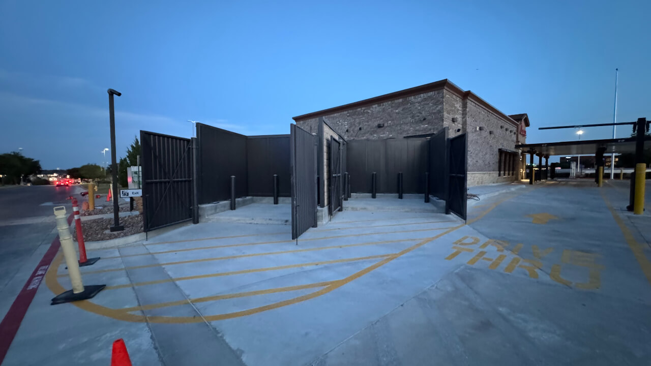 Building exterior with fenced utility area.