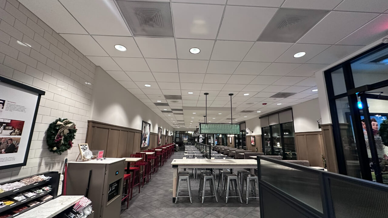 Modern restaurant interior with tables and chairs.