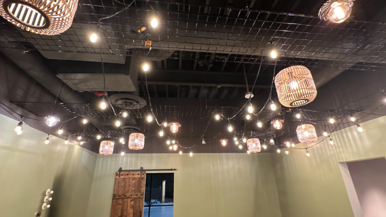 Ceiling with hanging lights and woven lamps.