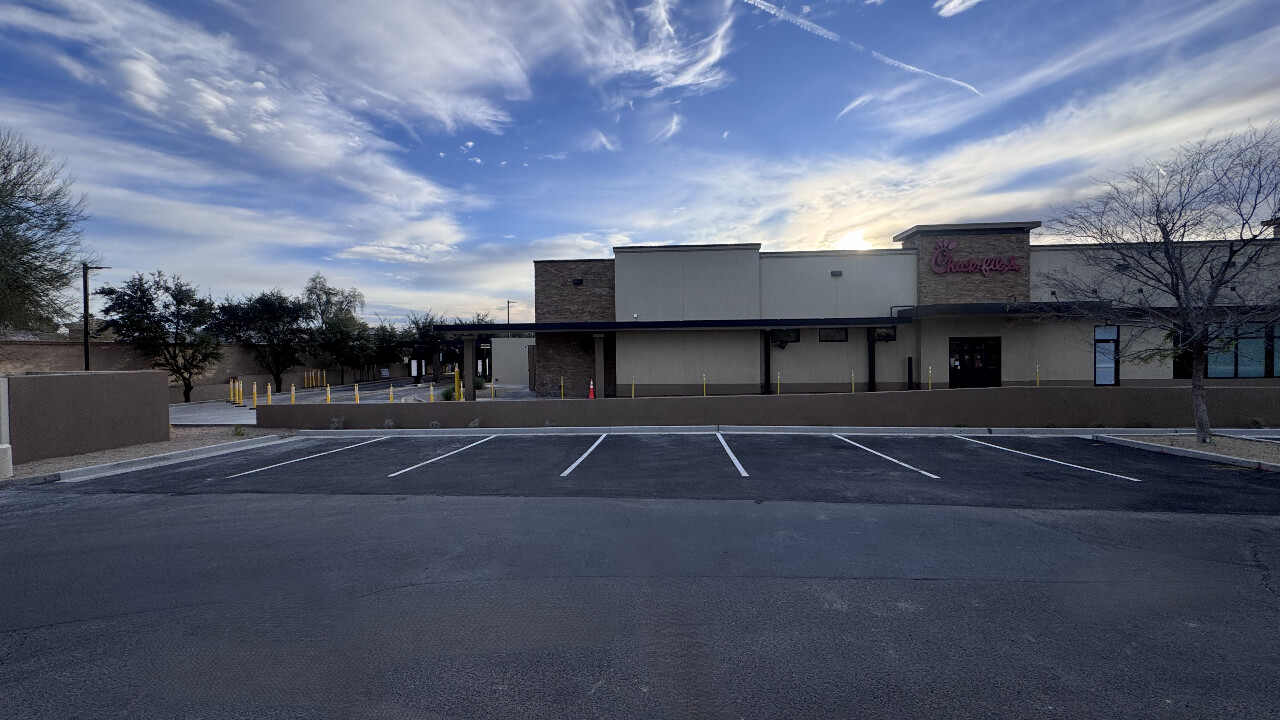 Empty parking lot in front of building.