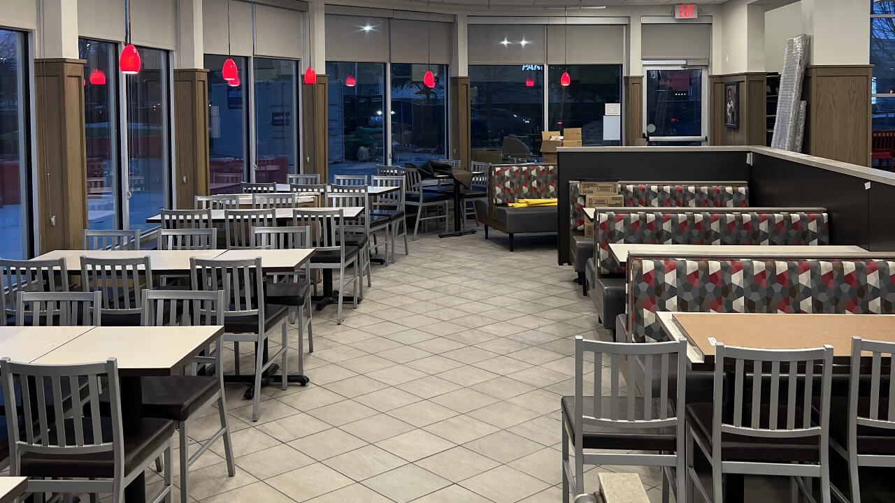 Empty fast food restaurant with tables and chairs.