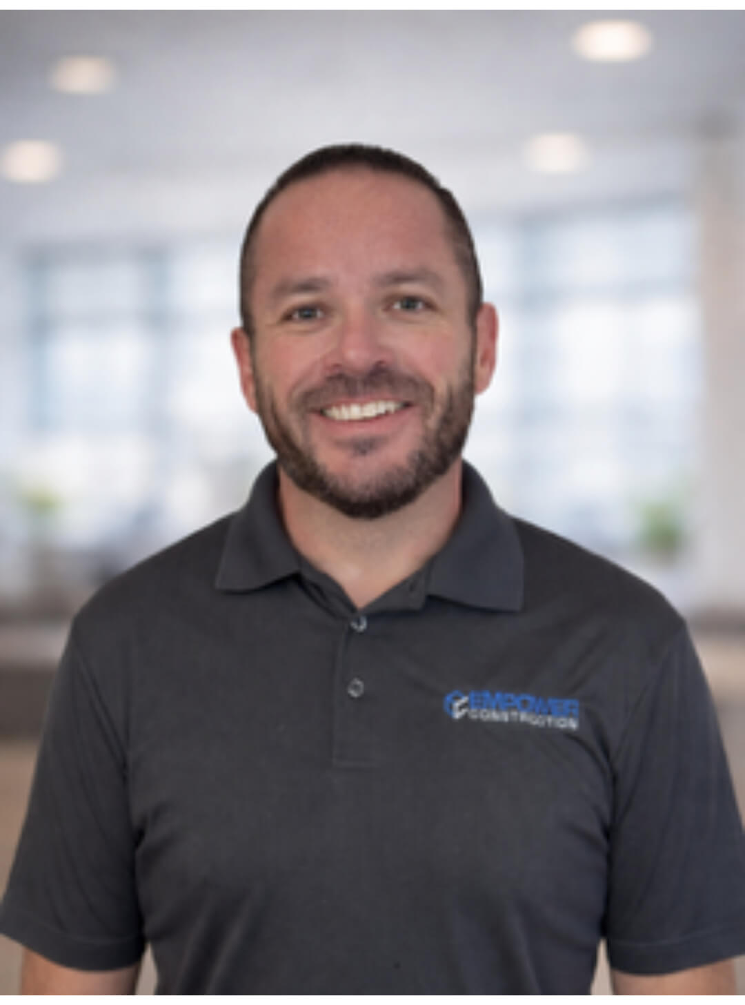 Man smiling in a dark polo shirt.