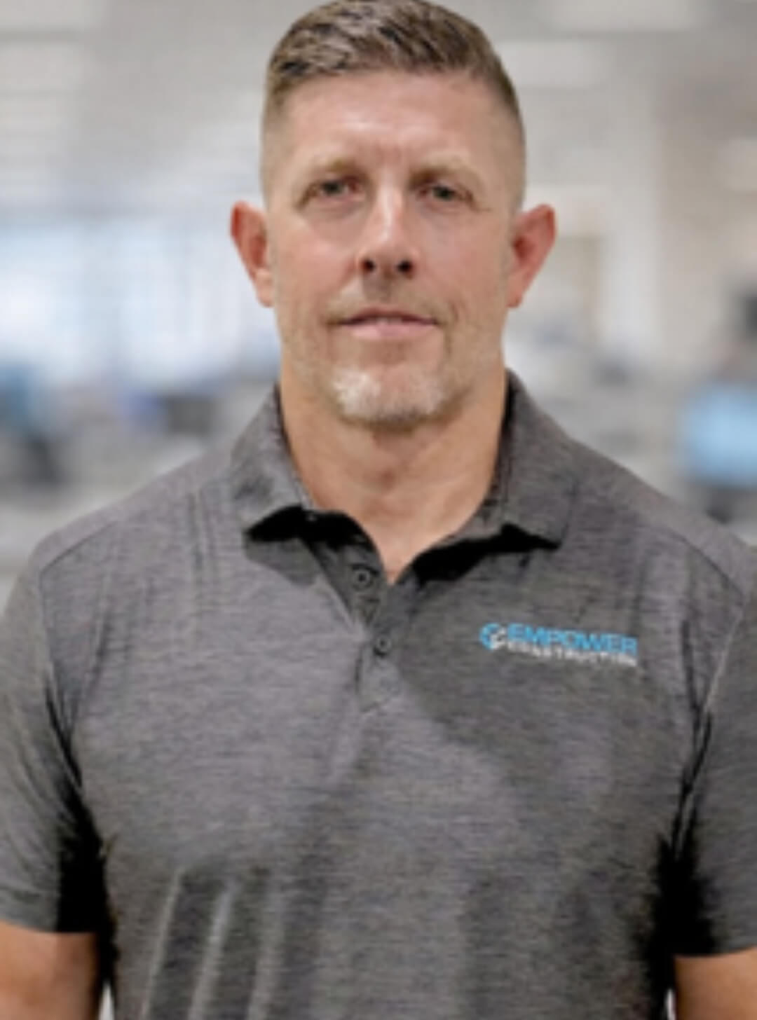 Man wearing a gray polo shirt indoors.