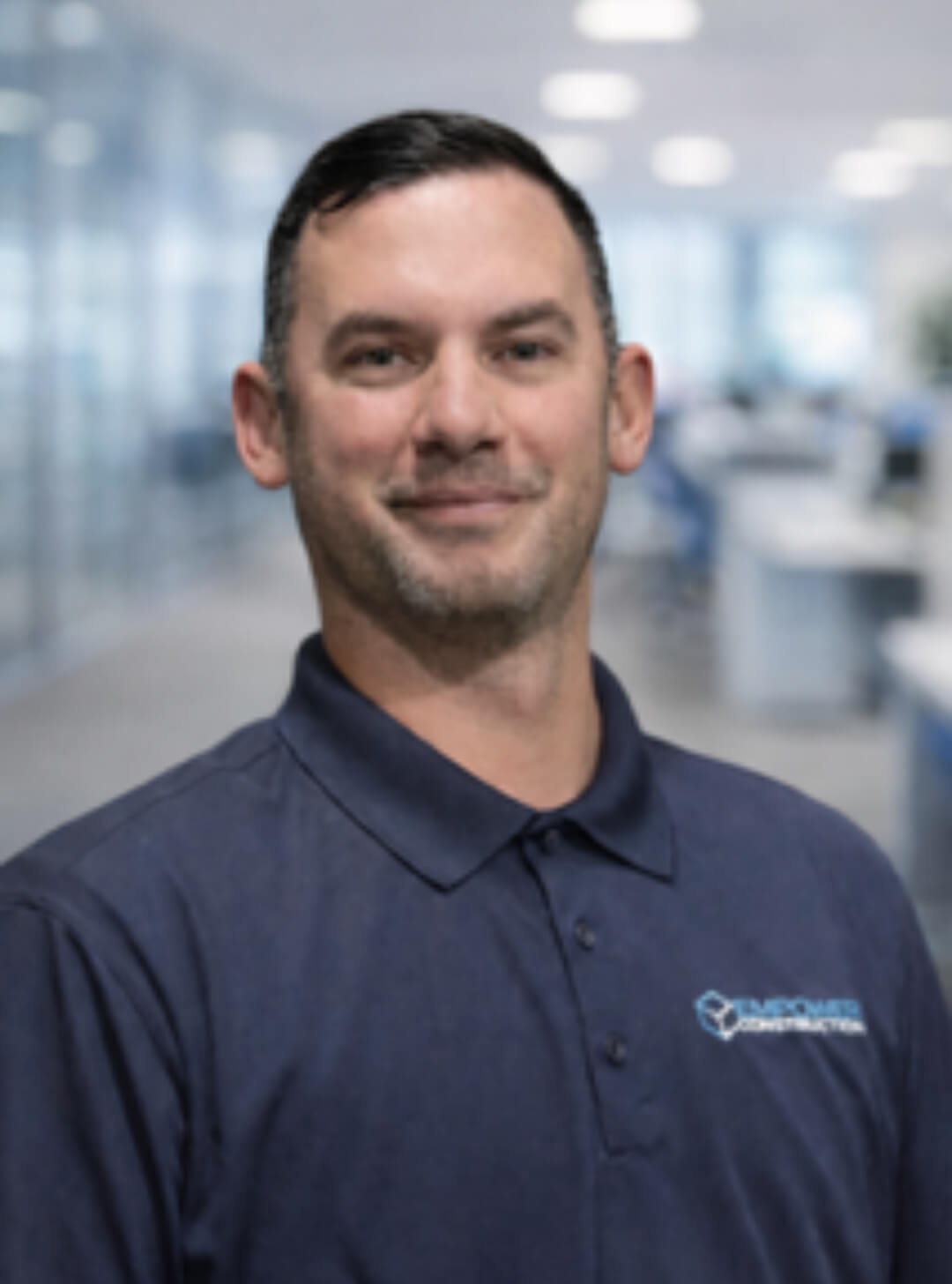 Man smiling in a modern office environment.