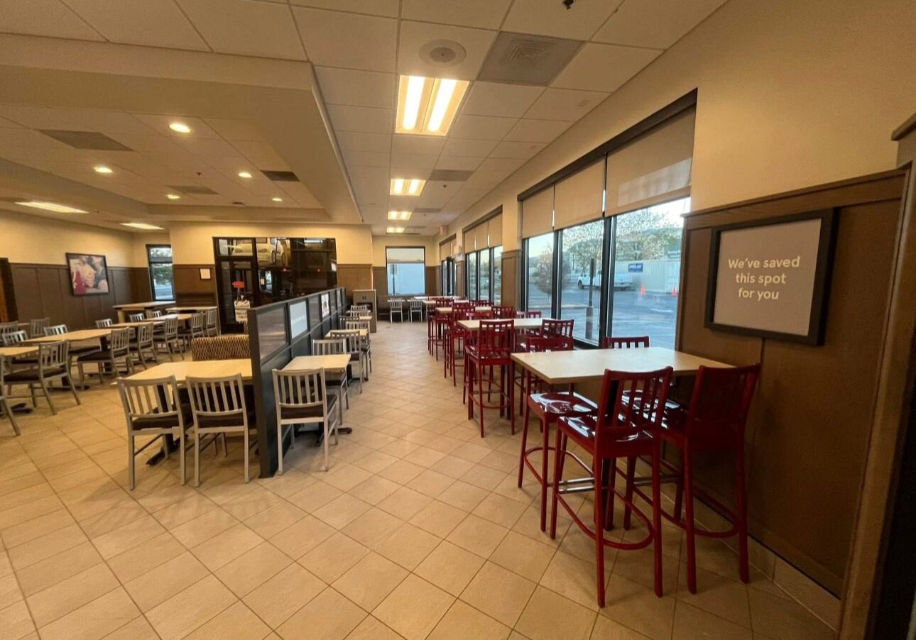 Bright, spacious dining area with tables and chairs near large windows.